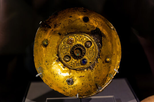 Eighth-century double-shelled bowl made from gilt-bronze and silver-gilt, ornamental central roundel with knotwork patterns under museum lighting