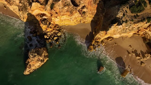 Drone top down view of Praia da Marinha beach in Algarve, Portugal, with ocean cliffs, sea stacks and blue Atlantic water. Top down view shot.