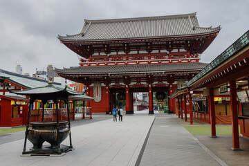 A man walks past a large incense burner in the courtyard of the historic Senso-ji temple in...