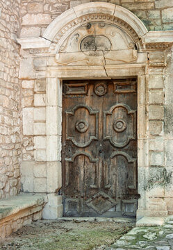 Alte Holzt&uuml;r mit einem verzierten Steinbogen in Simiane-la-Rotonde, Provence