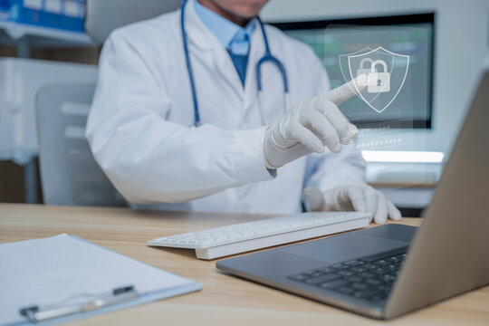 Medical personnel are using a laptop displaying a shield icon on the login screen, symbolizing the security of medical data, cybersecurity, privacy protection, and secure access to healthcare systems.