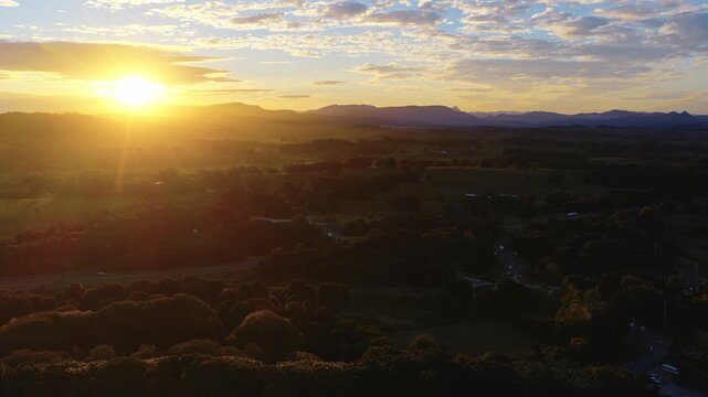 Aerial view of sunset over rural landscape with macadamia trees and farmland in Byron Bay, New South Wales, Australia.