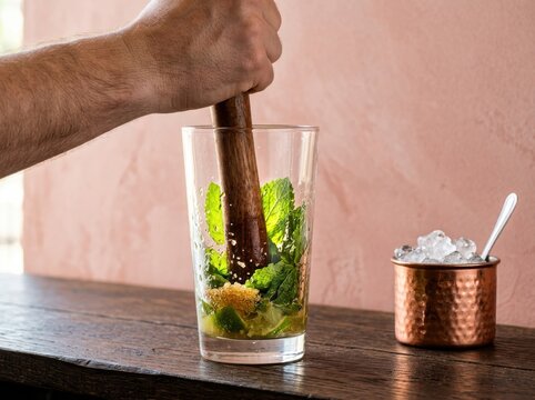 Fresh mojito preparation with mint and lime in a highball glass