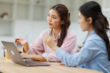 Obraz premium Asian businesswomen collaborating on a project, discussing new ideas and strategy in a modern office meeting, fostering teamwork, innovation, and professional development