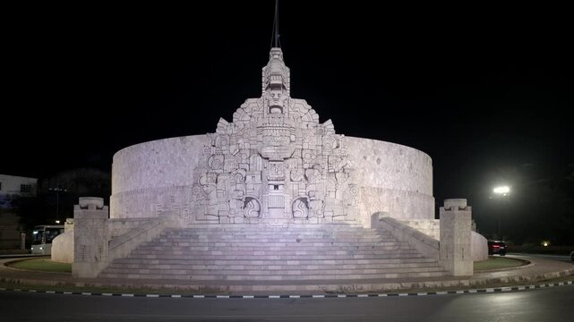 Vista nocturna del Monumento a la Patria, emblem&aacute;tico monumento de inspiraci&oacute;n maya ubicado sobre Paseo de Montejo en M&eacute;rida, Yucat&aacute;n, M&eacute;xico, iluminado contra un cielo oscuro.