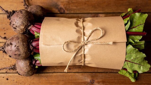 vegetable bundle wrapped in kraft paper with jute string on wooden table