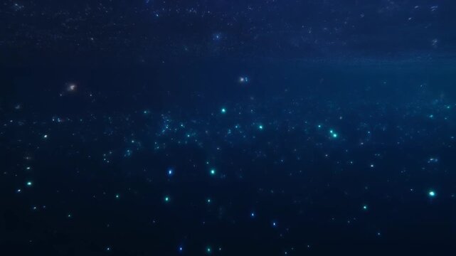 Bioluminescent plankton glowing in deep blue ocean water in slow motion