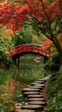 a serene Japanese garden. A red wooden bridge spans a calm pond, its reflection shimmering on the waters surface. A stone pathway leads to the bridge.