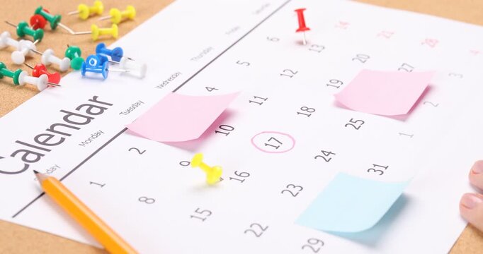 Planning. Woman marking date with marker and drawing pin at textured table, closeup