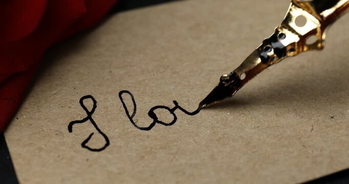 Writing phrase I Love You on card at table, closeup
