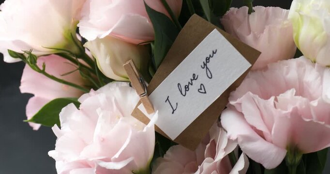 Card with phrase I Love You and bouquet of beautiful flowers on blurred background, closeup
