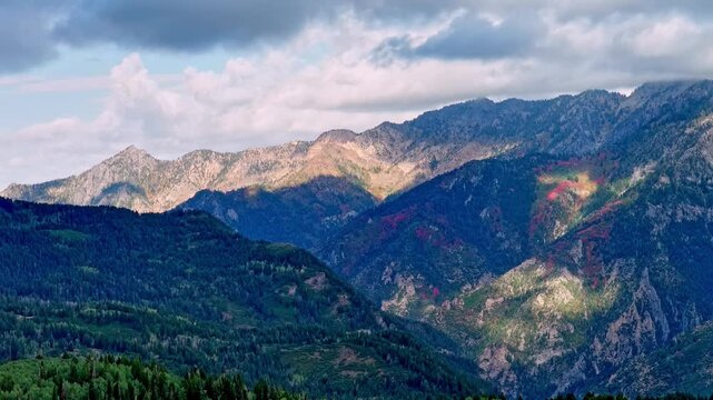Aerial view of the Alpine Loop Scenic Byway in the Wasatch Range Mountains with autumn foliage and cloud shadows flowing over the landscape, Utah County, Utah, United States.