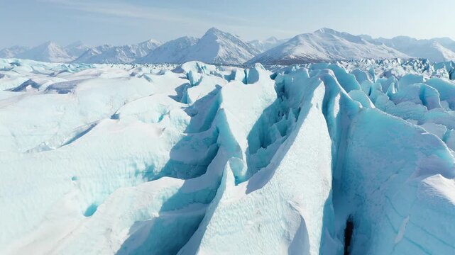 Aerial View of Glacial Ice Crevasses and Snowy Mountain Landscape
