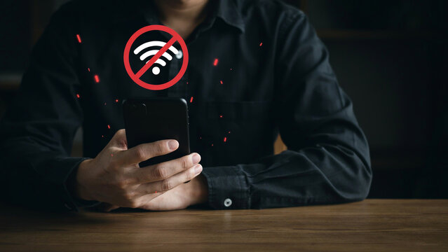 Man holding smartphone with no wifi signal icon indicating internet connection issue or loss.