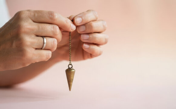 Woman holding a brass pendulum for dowsing and divination divination practice
