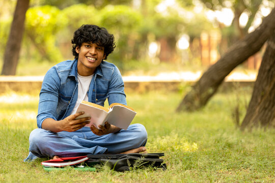 Indian male college student boy studying at park
