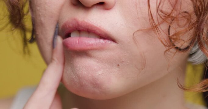 Close-up of a young woman examining her lips, highlighting natural beauty and skincare