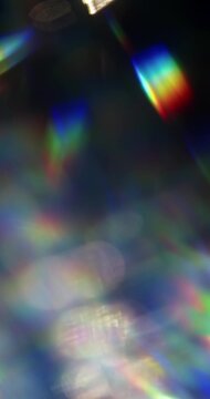 Light ray shining through a prism for beams of sparkling lights, shimmering bokeh, and a brilliant dazzling rainbow of lens flares. Visual effect of a light burst through swirling reflective glass.