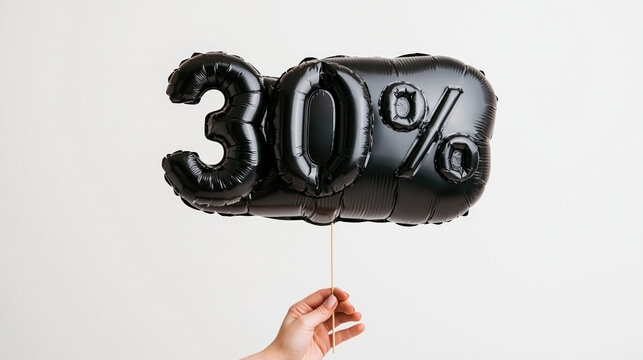 A hand holds a black balloon shaped like 30%, symbolizing a discount or special offer.