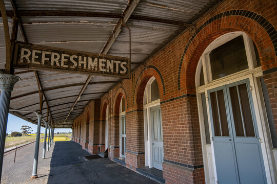 A weathered "Refreshments" sign beneath the ornate iron verandah of the historic Serviceton railway station in Victoria, Australia. Grandeur of a former rail hub now preserved as a heritage attraction