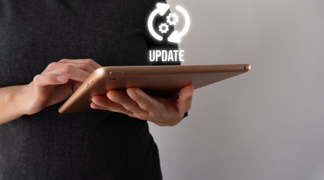 Person holds tablet with glowing update icon above it