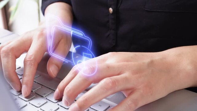Music files. Close-up of a businesswoman's hands working on her computer with a virtual icon of a folder and a musical note.
