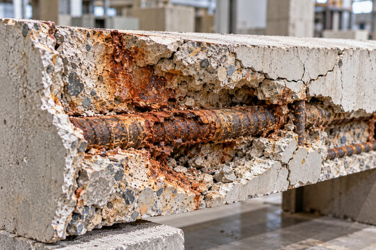 Cutaway reinforced concrete showing corroded rebar and severe spalling damage