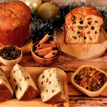Traditional Christmas panettone with candied fruit and raisins, sliced, in a Christmas party setting.