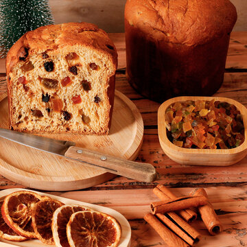 Traditional panettone with candied fruit and raisins, sliced for a Christmas dessert, with festive decoration.