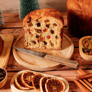Festive Christmas panettone with candied fruit and raisins, sliced a decorated table.