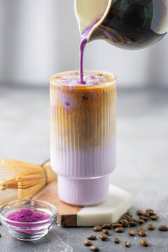 Ube latte with coffee in glass. Healthy vegan drink. Viral trendy asian beverage