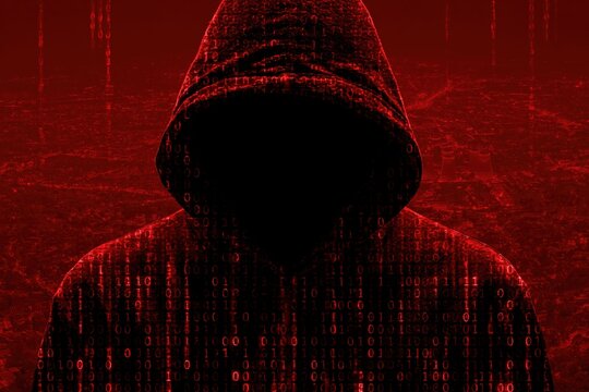 Hacker silhouette in hoodie with digital binary code background for cybersecurity data security