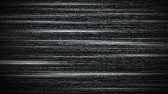 Abstract dark grainy texture with horizontal light streaks and subtle motion, perfect for background or visual effects in digital media and film.