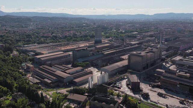 Aerial view of the Acciai Speciali Terni steel plant complex with industrial buildings and warehouses in Terni, Umbria, Italy.