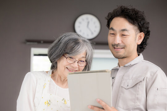 An image depicting a male staff member providing a home renovation estimate to a senior citizen, discussing renovation consultations, barrier-free design, home modifications, and housing for retiremen
