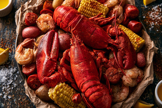 rustic seafood boil with whole lobsters, corn, and lemons