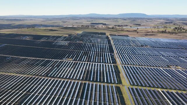 Aerial View Over Massive Solar Farm with Rows of Photovoltaic Panels