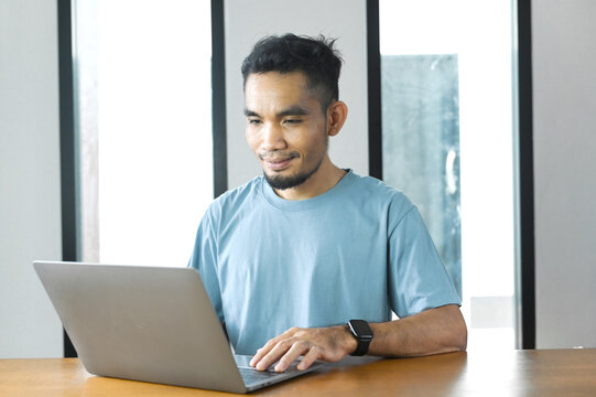 A relaxed man working from home on a laptop, enjoying a flexible lifestyle and a positive work experience.