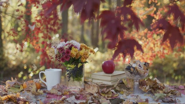 Cozy autumn table scene outdoors. Warm fall setup with leaves. Autumn coffee moment on table. Cozy fall table with flowers. Autumn picnic table setting.