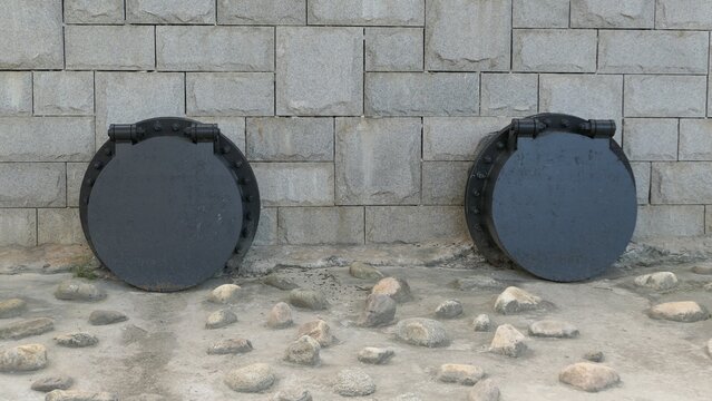 Two Circular Stormwater Outfall Gates on a Stone Retaining Wall