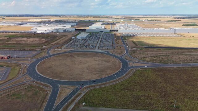 Debrecen, Hungary BMW Group vehicle manufacturing plant with EV assembly facilities, solar panels and logistics infrastructure beside fields, viewed by drone.