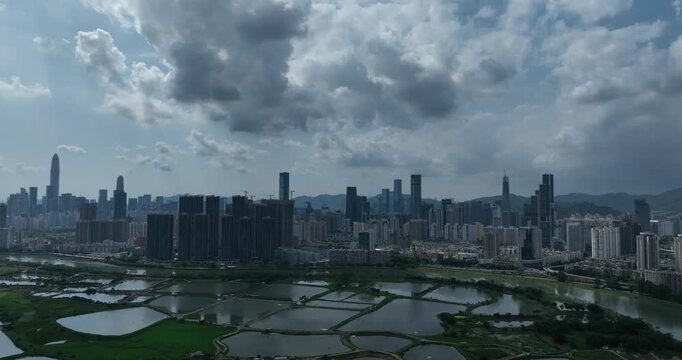 Rural green fields with fish ponds between Hong Kong and skylines of Shenzhen, China	