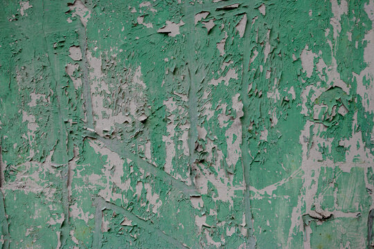 A close-up view of peeling paint and weathered texture on a dirty wall, resembling a  grunge effect; suitable for backgrounds or 3D asset texturing in digital imaging.