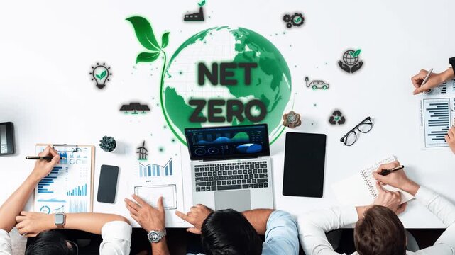 A dynamic team collaborates on achieving net zero goals, analyzing data and strategies with modern technology in a stylish office environment, focusing on sustainability initiatives. Raster