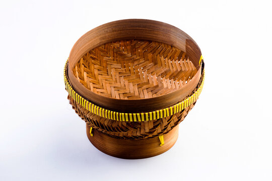 A ceting bambu is a traditional woven bamboo container for storing rice, isolated against a white background.