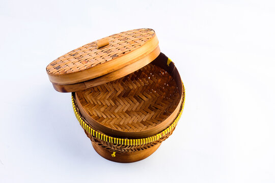 A ceting bambu is a traditional woven bamboo container for storing rice, isolated against a white background.