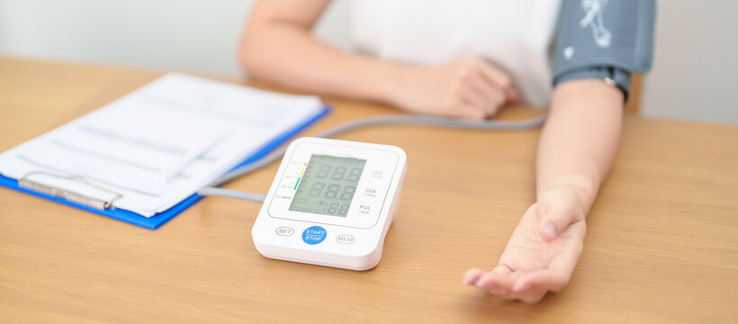 woman checking Blood pressure by Blood pressure monitor with Cuff. Systolic, SYS, Diastolic, DIA, Pulse, Hypertension, Hypotension, Heart rate, Cardiovascular Disease and May World hypertension day