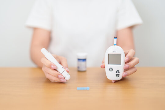 Hand checking Diabetes or Blood glucose self testing by digital blood glucose meter with lancet pen. high blood sugar level, World Diabetes Day, Glycemia, Hypoglycemia, Hyperglycemia and insulin