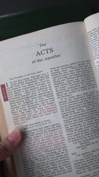 Opening to the book of Acts of the New Testament in the Holy Bible. New Revised Standard Version. Vertical video.