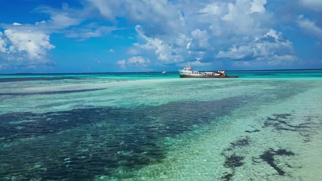 Side angle shot of abandoned metal boat rusting in clean ocean water. Concept of environmental impact, marine pollution, nature, corrosion, and climate change